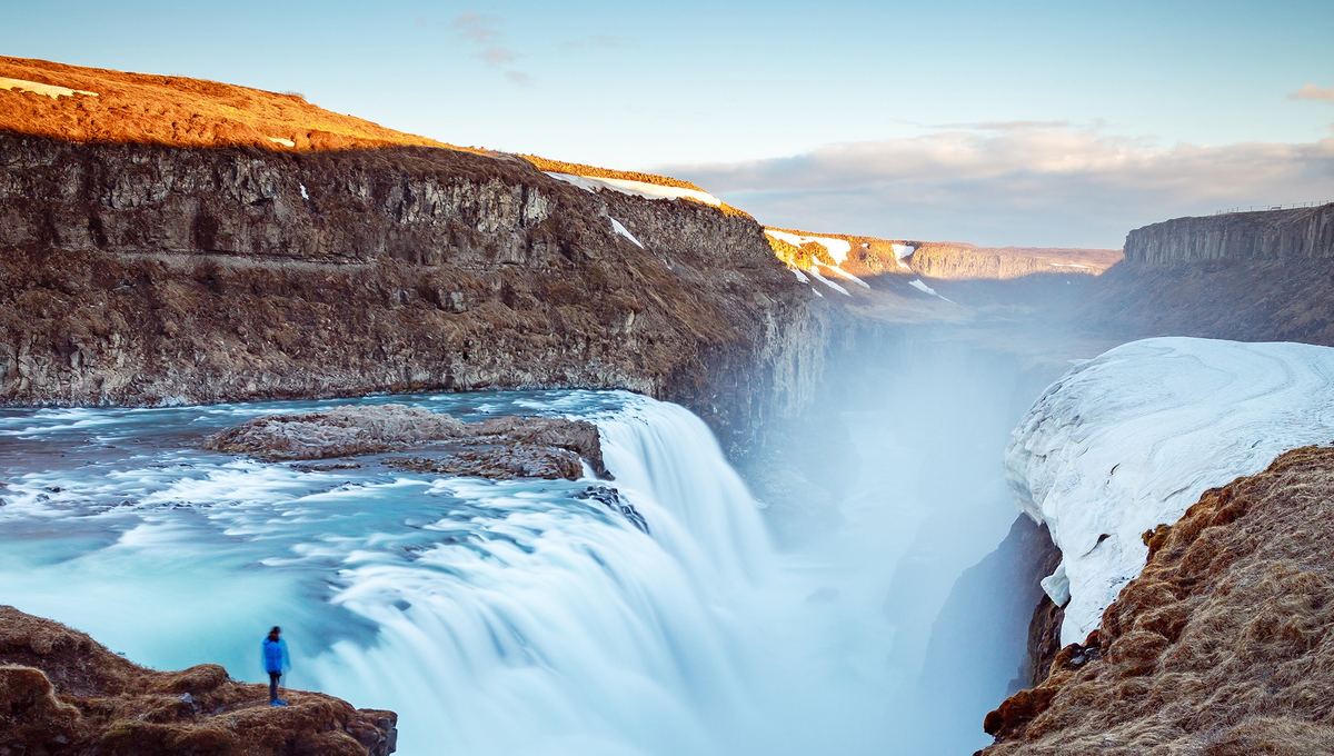 Iceland cruises - Traveller by waterfall