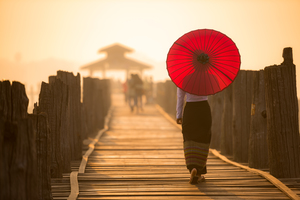 Burmese woman with umbrella on U Bein Bridge, Mandalay, Myanmar