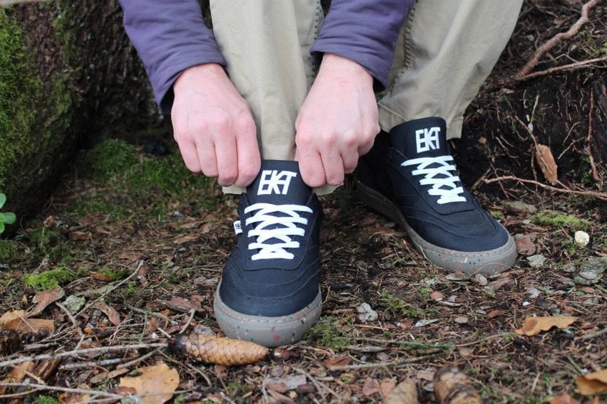 A wearer puts on a black pair of trainers